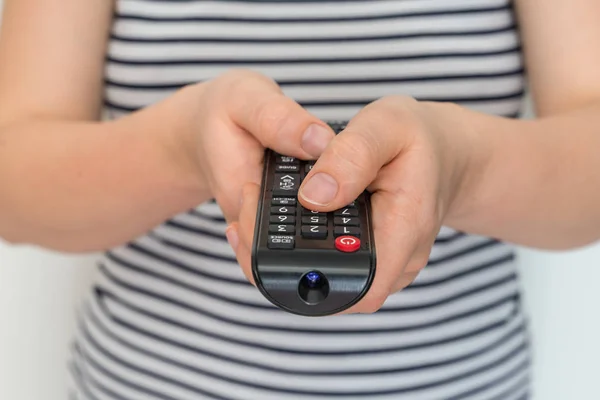 Remote control in female hands pointing to TV Royalty Free Stock Images