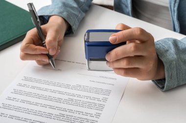 İş kadını ofiste belgeler damga koyarak
