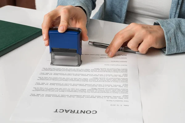 Business woman putting stamp on documents in the office — Stock Photo, Image