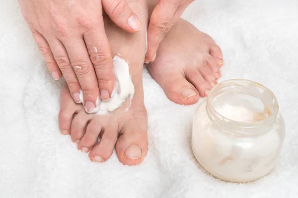 Mulher aplicando creme hidratante em seus pés — Fotografia de Stock