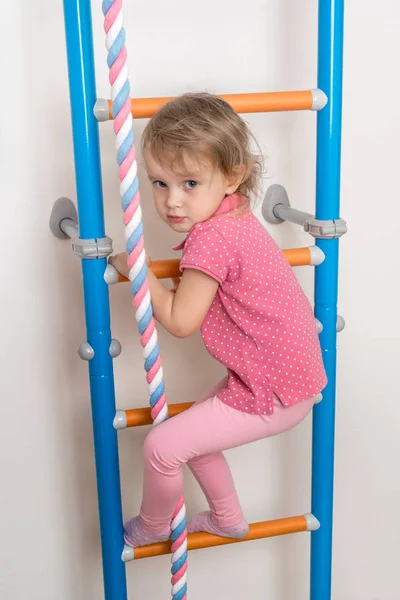 Pequena menina feliz escalando a escada — Fotografia de Stock