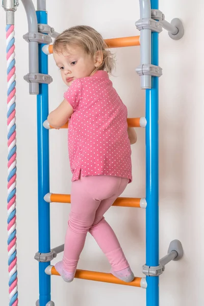 Маленькая счастливая девочка поднимается по лестнице — стоковое фото