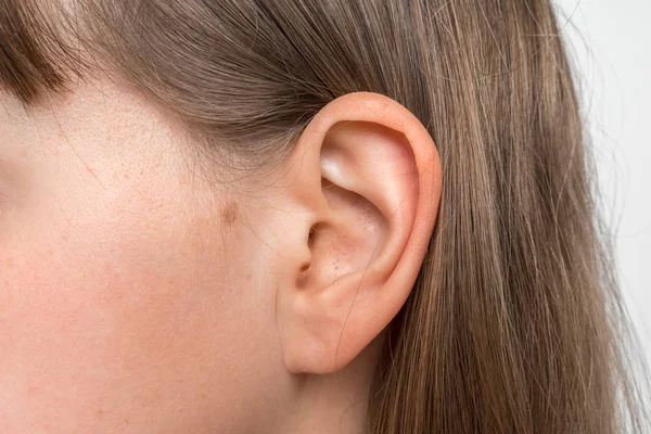 Zbliżenie ludzkiej głowy z ucha żeńskiego — Zdjęcie stockowe