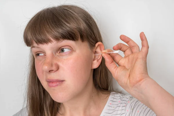 女性クリーニング彼女の汚い耳とともに綿棒 — ストック写真
