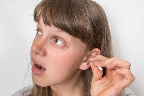Женщина чистит уши ватным тампоном — стоковое фото