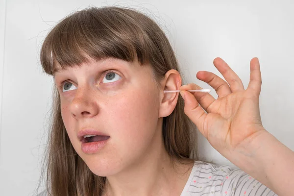 Kvinnan rengör sina smutsiga öron med bomullstuss — Stockfoto