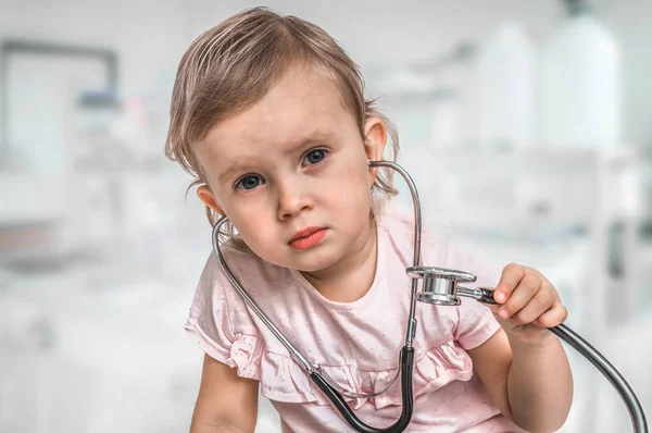 Pequeño bebé juega médico con estetoscopio — Foto de Stock