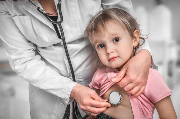 Kinderarts arts behandeling van een klein meisje door stethoscoop — Stockfoto