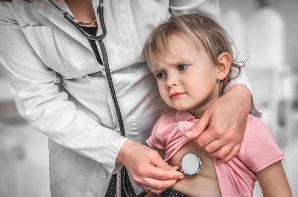 Kinderarts arts behandeling van een klein meisje door stethoscoop — Stockfoto