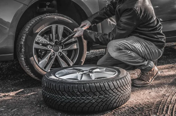 El hombre está cambiando la rueda del coche de verano, neumático antes del invierno — Foto de Stock