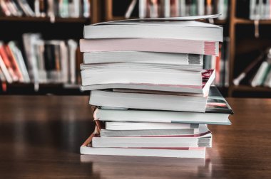 Kütüphanedeki masanın üzerinde kitap yığını