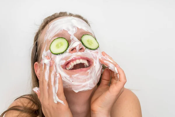 Mujer con máscara de crema natural y pepinos en la cara — Foto de Stock