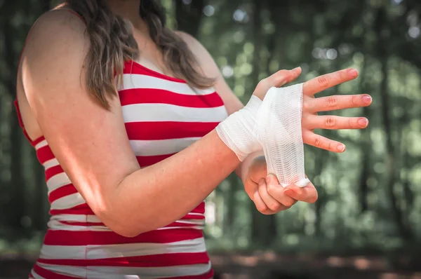 Mujer que se aplica vendaje en la mano después de una lesión —  Fotos de Stock