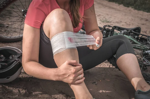 Donna con dolore al ginocchio dopo essere caduta dalla bicicletta — Foto Stock