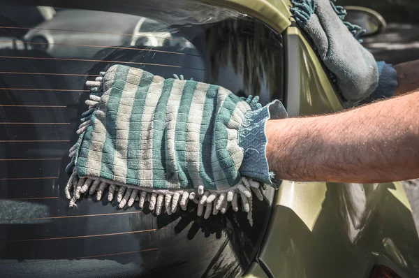 Чоловік миє свій автомобіль - концепція миття автомобілів і прибирання автомобілів — стокове фото