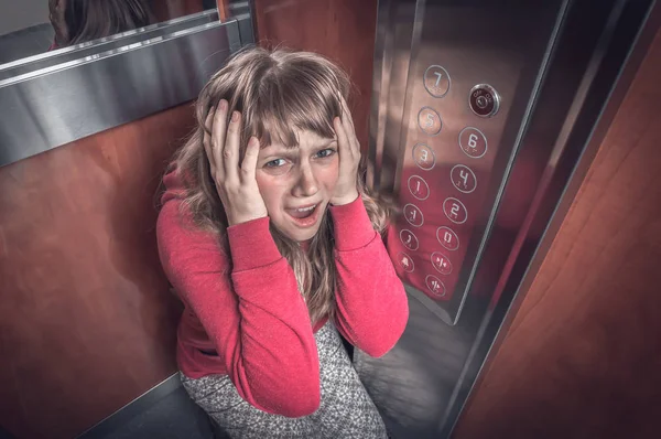 Schockierte Frau mit Klaustrophobie im fahrenden Fahrstuhl — Stockfoto