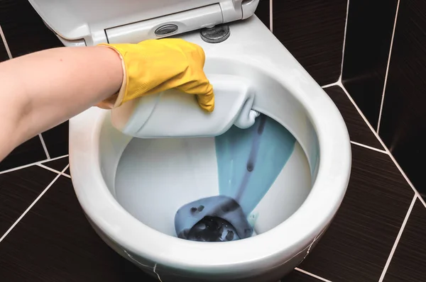 La mujer está limpiando el inodoro usando detergente — Foto de Stock