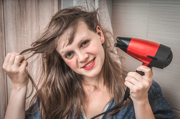 Chica de moda con secador de pelo seca su cabello — Foto de Stock