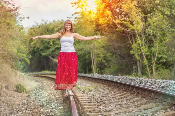 Jeune femme marchant sur les rails — Photo