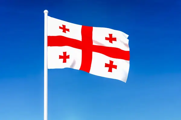 在蓝天背景上飘扬的格鲁吉亚国旗 — 图库照片