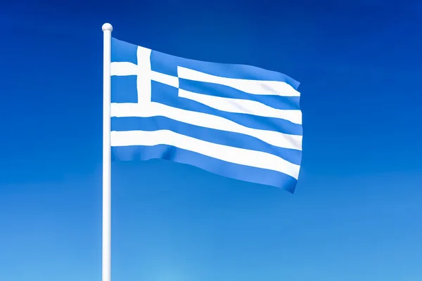 挥舞着国旗的希腊蓝蓝的天空背景上 — 图库照片