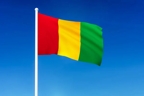 在蓝天背景下挥舞着几内亚国旗 — 图库照片