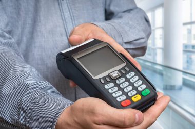 Adamın elinde ödeme terminali - banka para transferi kavramı