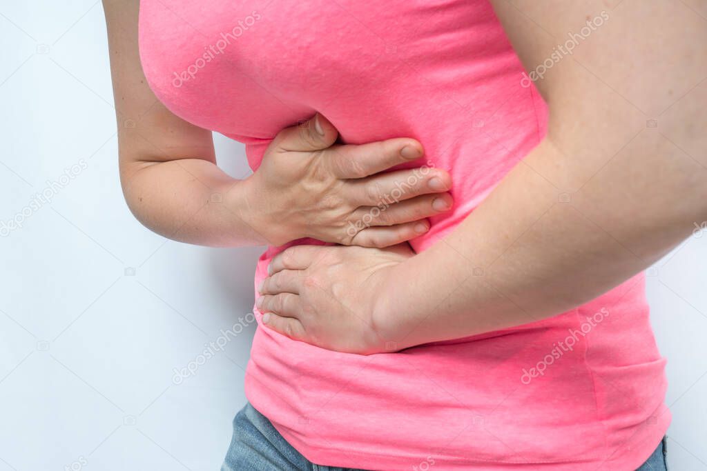 Woman with stomach pain is holding her aching belly - body pain concept