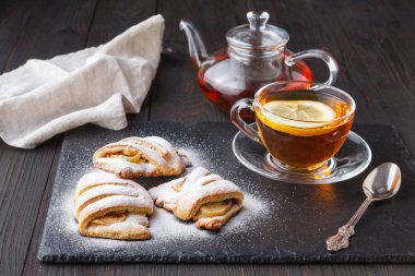 Kruvasan ve karanlık bir arka plan üzerinde çay