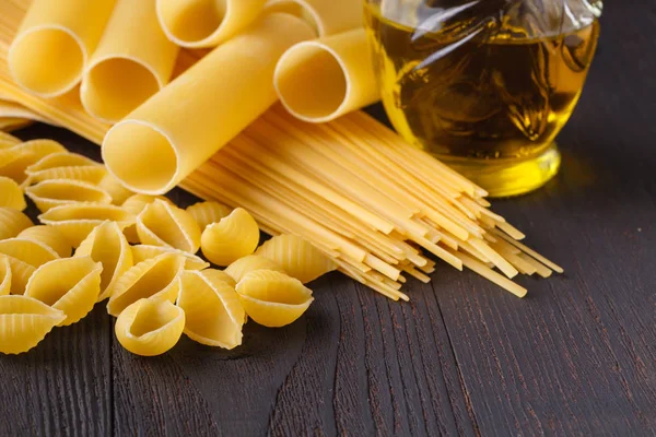 Composition Uncooked Italian Pasta Spaghetti Farfalle Fusilli Dark Wooden Background — Stock Photo, Image