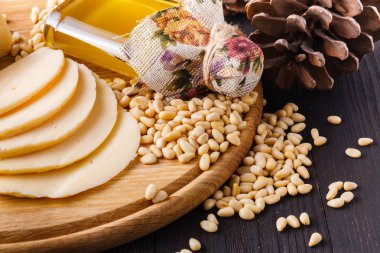 Sedir koni ile fındık ve ahşap bir arka plan üzerine bir cam şişe. Doğal vitamin ve mineral kaynağıdır. Halk hekimliği ve pişirme kullanılan