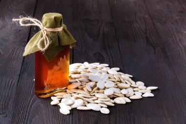 Ahşap masa üzerinde küçük şişede saf Kabak yağı