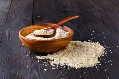 Cam kavanoz ve susam tohumlar üzerinde tahta kaşık susam yağı