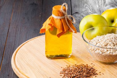 Cam sürahi ahşap masa üzerinde kaşık ve keten tohumu yağında üzerinde kahverengi keten tohumu. Keten yağı omega-3 yağ asidi zengindir.