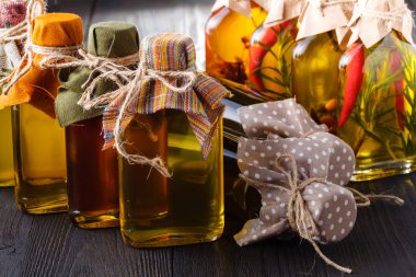 Otlar ve baharatlar, kırmızı ve sarı renkli yağda korunmuş birkaç şişe