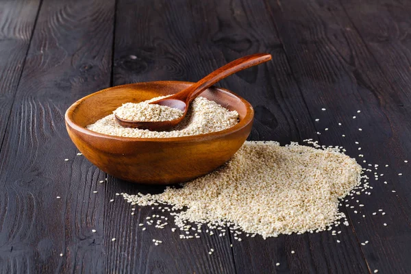 Cam kavanoz ve susam tohumlar üzerinde tahta kaşık susam yağı