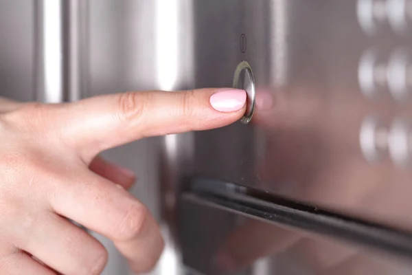 Закройте Женскую Руку Пользуясь Микроволновой Печью Кухне — стоковое фото