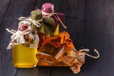 Ahşap arka plan üzerinde cam şişe içinde çeşitli mutfak yağı