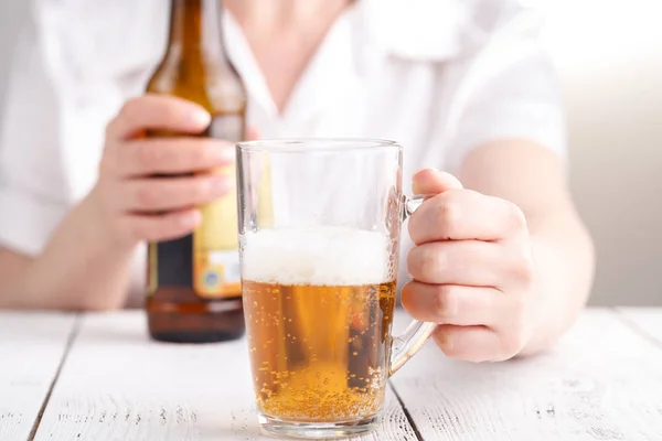 Female pouring beer in glass mug, relax concept
