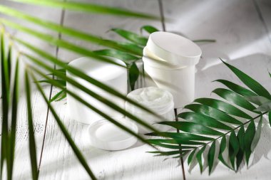 Kozmetik krem ve beyaz masada güzel spa konteynırları