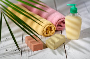 Doğal organik banyo ürünleri. havlu, sabun, şampuan şişesi ve yaprakları. Güzellik arka plan. Mockup tasarım için