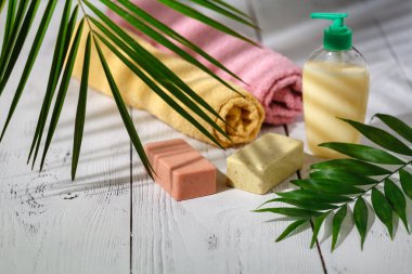 Doğal organik banyo ürünleri. havlu, sabun, şampuan şişesi ve yaprakları. Güzellik arka plan. Mockup tasarım için