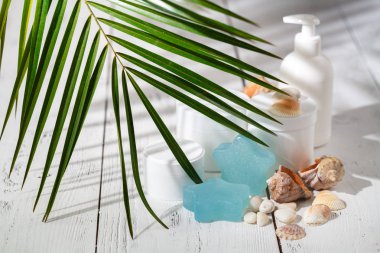 Kozmetik şişe kapları ile yeşil bitki yaprakları