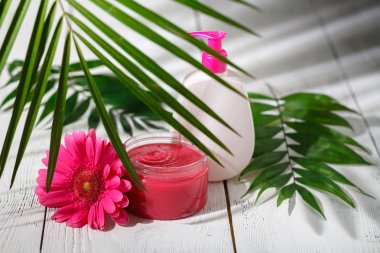 Kozmetik şişe kapları ile yeşil bitki yaprakları