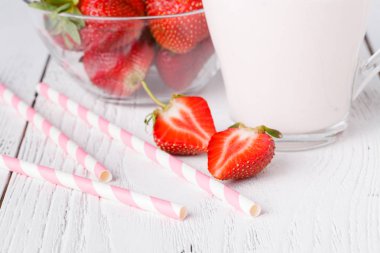 Çilek ve beyaz ahşap masa üzerinde süt İçecek