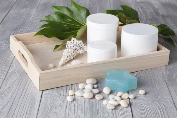 Spa yordamı kavramı, farklı kozmetik kavanoz ve şişe üzerinde ahşap masa