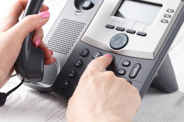 telefon alıcı ve çevirme numarası tutan el