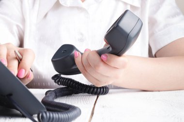 telefon alıcı ve çevirme numarası tutan el