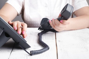 telefon alıcı ve çevirme numarası tutan el