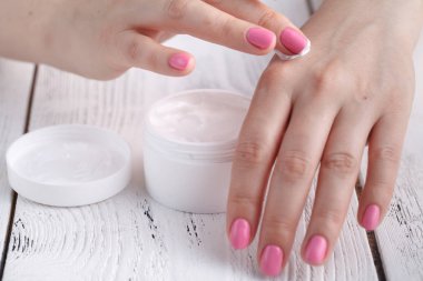 güzel kadın bir cilt bakım ürünü, nemlendirici veya Kuru cildi dikkat çekici losyon kullanarak. Eller içinde nemlendirici krem